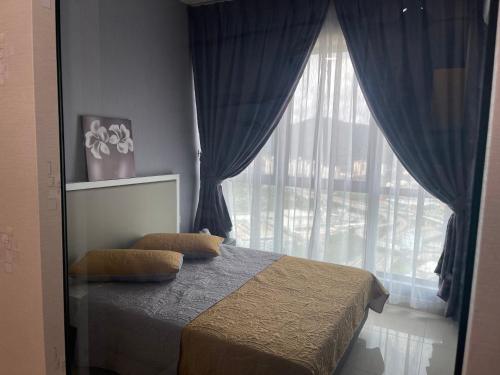 1 dormitorio con cama y ventana grande en Studio Unit@ Ampang Ukay, en Ampang