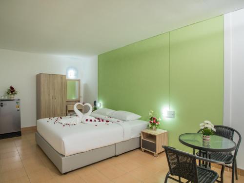 1 dormitorio con 1 cama, mesa y sillas en TJ Guesthouse, en Pattaya central
