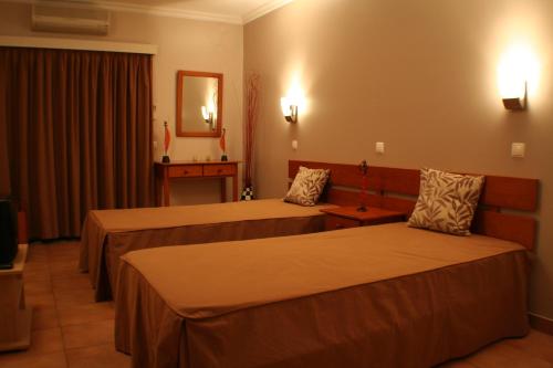 a hotel room with two beds and a mirror at Vitor s Plaza Mariosilvat in Portimão