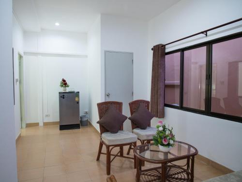 sala de estar con sillas, mesa y ventana en TJ Guesthouse, en Pattaya central