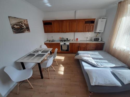 uma cozinha com uma cama, uma mesa e cadeiras em Lux Apartment in the City Center em Mukacheve