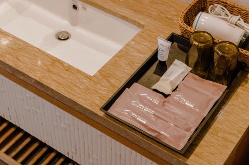 a bathroom counter with a sink and a basket at ISPAVITA B&B Resort in Jiaoxi