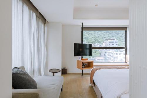 a hotel room with a bed and a tv at ISPAVITA B&B Resort in Jiaoxi