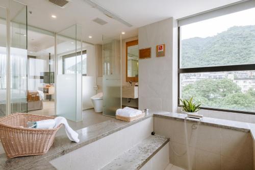 a bathroom with a glass shower and a sink at ISPAVITA B&B Resort in Jiaoxi