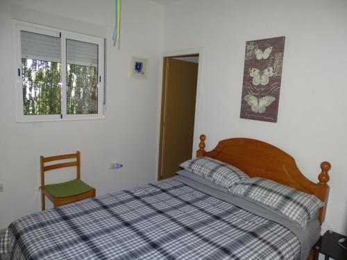 1 dormitorio con cama, ventana y silla en Rickaty Lodge Bed and Breakfast, 2 star Hotel, Plane spotting Hotel, Gran Canaria Airport LPA, Gran Canaria, Spain en Las Puntillas