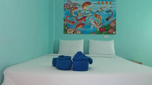 a bed with two blue stuffed animals sitting on it at Stella Resort Khanom in Khanom
