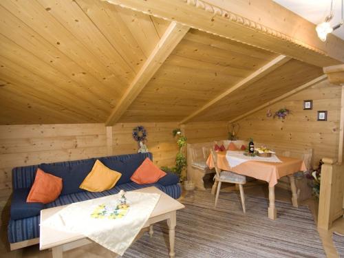 een woonkamer met een blauwe bank en een tafel bij Am Großwaldbach - Chiemgau Karte in Inzell
