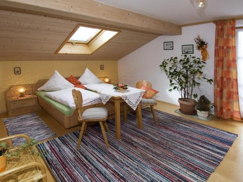 Habitación con mesa, cama y alfombra. en Am Großwaldbach - Chiemgau Karte, en Inzell