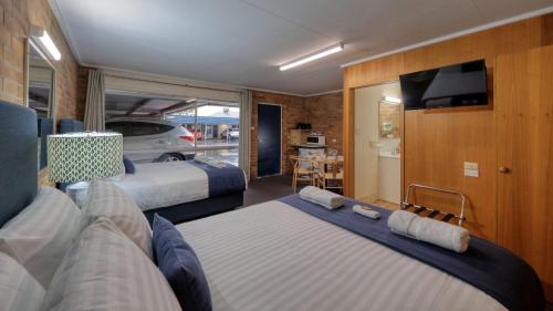 a room with two beds and a tv in it at Border Motel in Goondiwindi