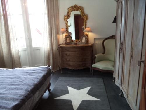 - une chambre avec un lit, un miroir et une chaise dans l'établissement Toki Alai, à Saint-Jean-de-Luz