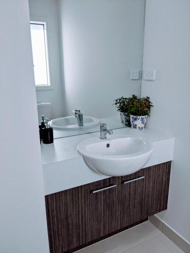 a bathroom with a sink and a mirror at Tarneit Treat in Tarneit