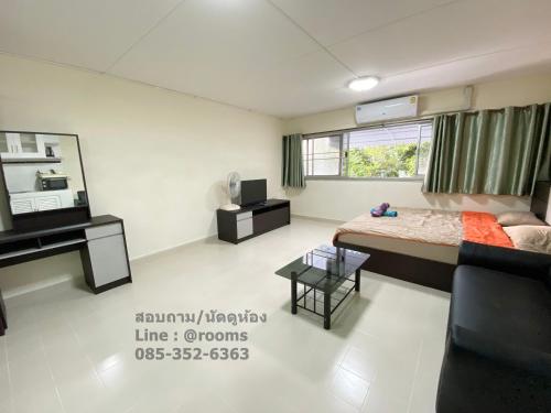 a bedroom with a bed and a couch and a table at ป็อปปูล่าคอนโด เมืองทองธานี ใกล้ Impact 酒店 公寓 in Thung Si Kan