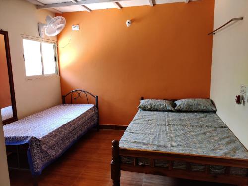 a bedroom with two beds and a window at Hanakodu homestay in Sringeri