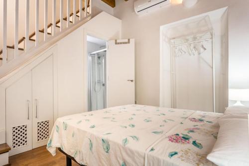 Stunning apartment in central Seville في إشبيلية: غرفة نوم بيضاء بسرير ودرج
