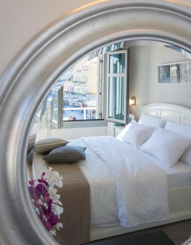 a bedroom with a large white bed with a window at Casa Del Porto in Chania