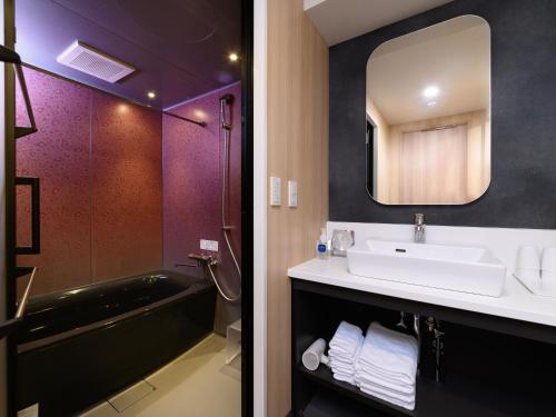 a bathroom with a bathtub, sink, mirror and bath tub at MIMARU TOKYO UENO EAST in Tokyo