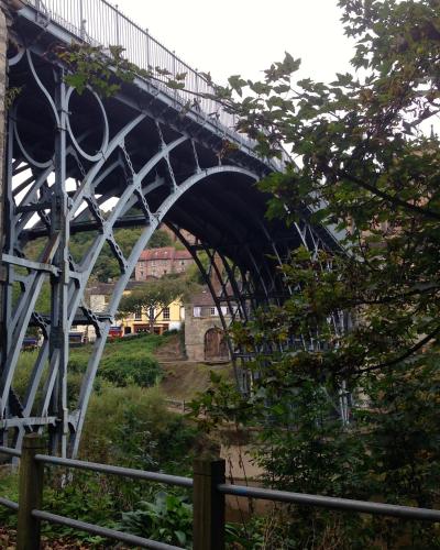 a bridge over a river next to a fence at Bridge View Guest House in Ironbridge