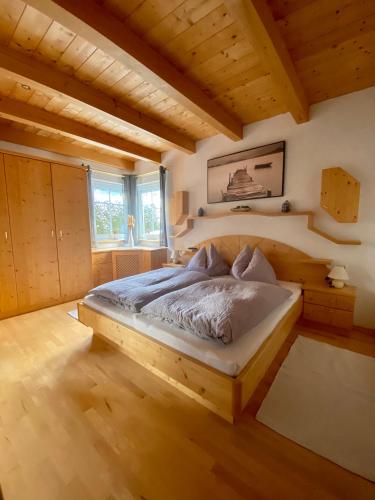 a bedroom with a bed in a room with wooden ceilings at AlpenApartment mit NationalparkCard in Bramberg am Wildkogel