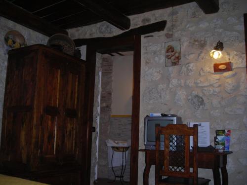 a room with a wooden cabinet and a table and a tv at La Locanda delle Streghe - Relais Ristorante in Castel del Monte