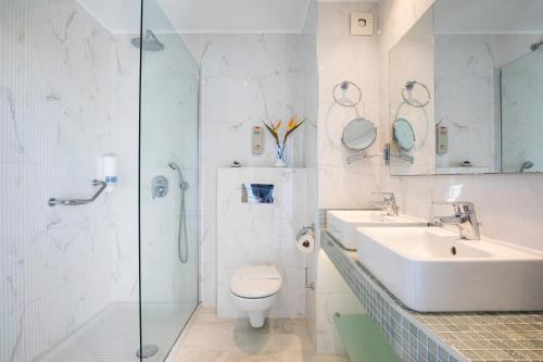 a bathroom with a sink and a toilet and a shower at Kolymbia Bay Art Boutique Hotel - Adults Only in Kolimbia