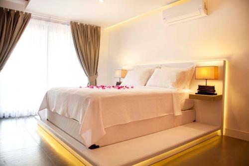 a bedroom with a large white bed with a window at PAYAM BUTİK OTEL in Datca