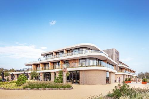 a large building with a lot of windows at Duinhotel Breezand in Vrouwenpolder