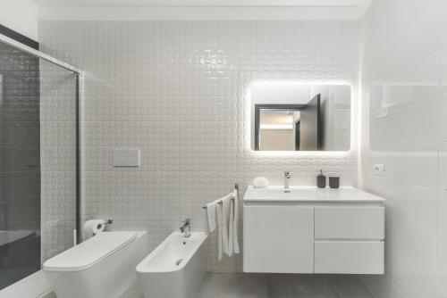 baño blanco con lavabo, bañera y aseo en Guest House Foligno Porta Romana, en Foligno