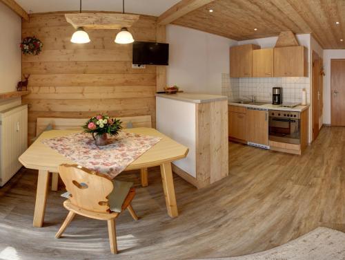 a kitchen with a wooden table and a wooden floor at Beim Bretzner - Chiemgau Karte in Inzell