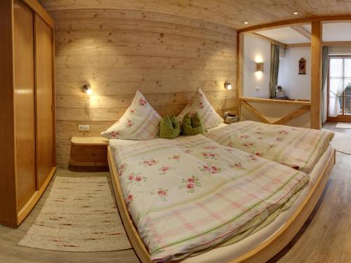 a bedroom with a large bed in a wooden wall at Beim Bretzner - Chiemgau Karte in Inzell