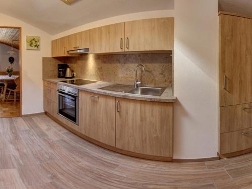 a kitchen with wooden cabinets and a sink at Beim Bretzner - Chiemgau Karte in Inzell