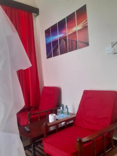a room with two red chairs and a table at Ocean View Nyali Boutique Hotel in Nyali
