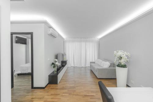 un soggiorno bianco con divano e specchio di Guest House Foligno Porta Romana a Foligno