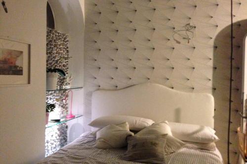 a bed with a white padded headboard in a bedroom at Boutique by the Sea in Positano
