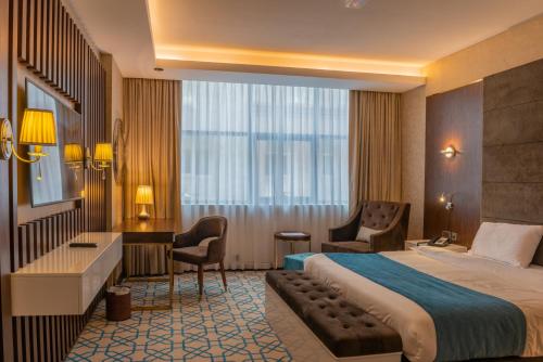 a hotel room with a bed and a desk at Royal Crown Hotel in Muscat