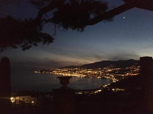 a view of a city at night with the water at Petit avec classe Sanremo in Sanremo