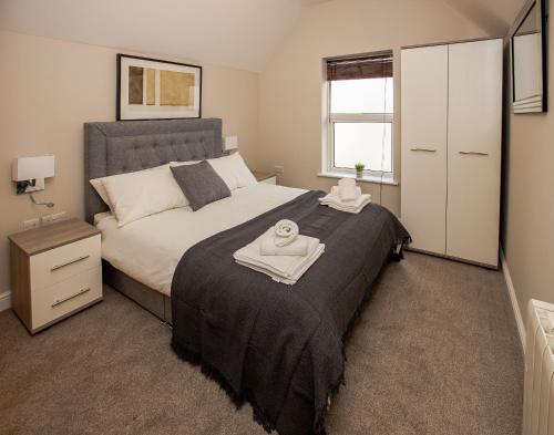 a bedroom with a bed with a towel on it at Spacious New One Bed Flat in the Heart of Reading in Reading