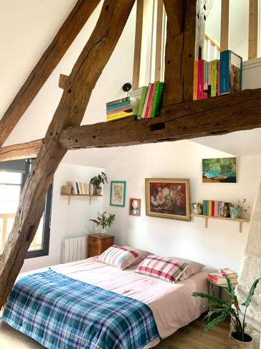 - une chambre avec un lit et des livres sur le mur dans l'établissement Maison Léontine, à Bernay