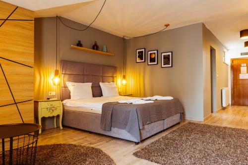 a bedroom with a large bed and a room with a table at Семеен хотел АРИЗОНА in Pavel Banya