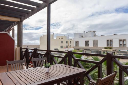 a wooden table on a balcony with a view of the beach at Sunset in paradise in Cotillo