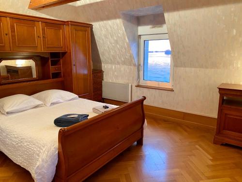 1 dormitorio con cama y ventana en Gîte Loirizon vue Loire 4 personnes, en Ingrandes