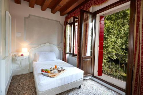 um quarto com uma cama com uma tigela de fruta em Hotel Villa Patriarca em Mirano