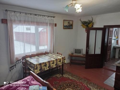 a living room with a table and a window at Садиба Брусний in Mykulychyn