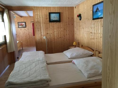 two beds in a room with wooden walls at Ferienbungalow Karnitz/Rügen in Karnitz