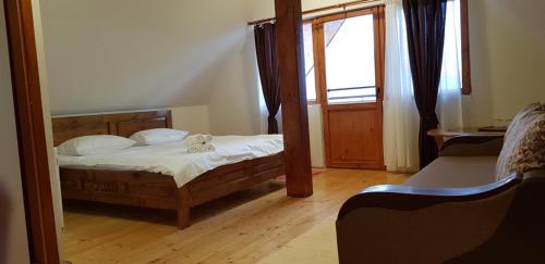 a small bedroom with a bed and a mirror at Pensiunea Printul Vlad in Sibiel