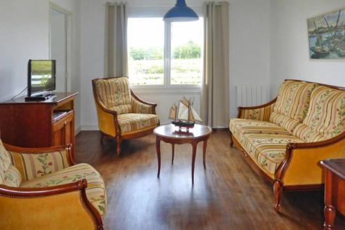 un salon avec un canapé, des chaises et une table dans l'établissement Detached House near beaches, à Esquibien