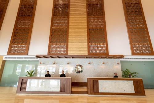 a lobby with three men standing at the reception desks at VIVANA in Dhanbād