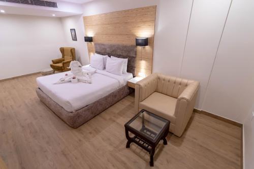 a hotel room with a bed and a chair at VIVANA in Dhanbād