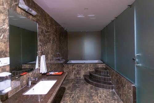 a bathroom with three sinks and a mirror at VIVANA in Dhanbād