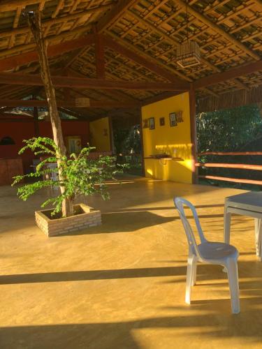 a white chair and a table and a tree at Sitio Samtielly Hospedagem e Day Use in Itacaré