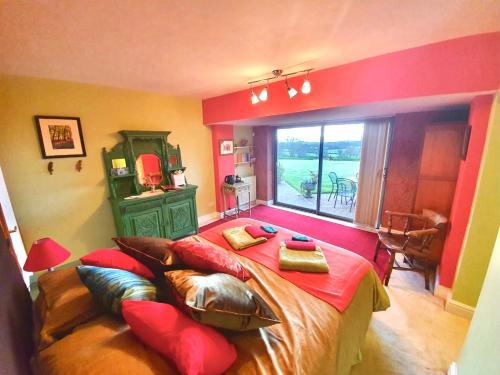 a bedroom with a bed with red walls and a window at Seven Acre Corner B&B in Exmouth